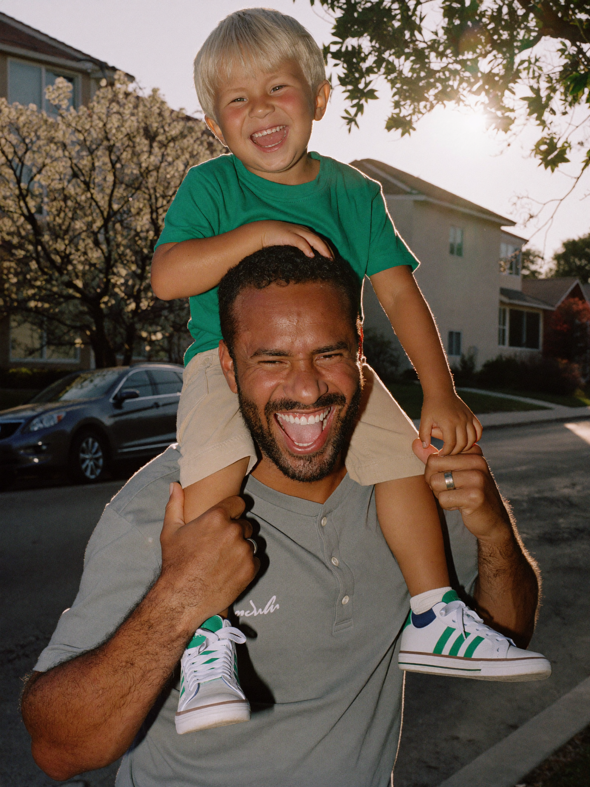 Father carrying his son on his shoulders at golden hour